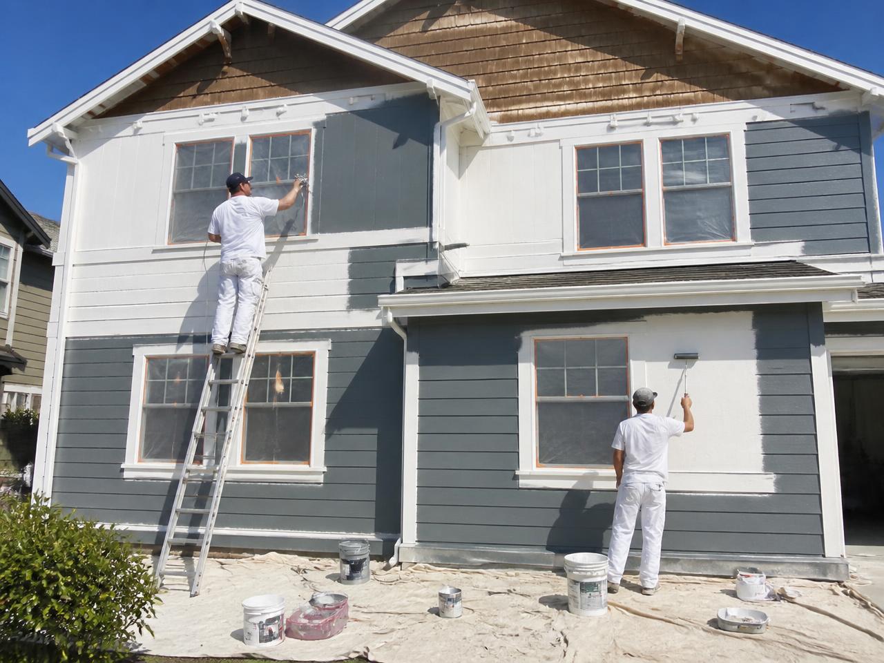 SMG Plastering painter applying exterior paint to a home in Media, PA