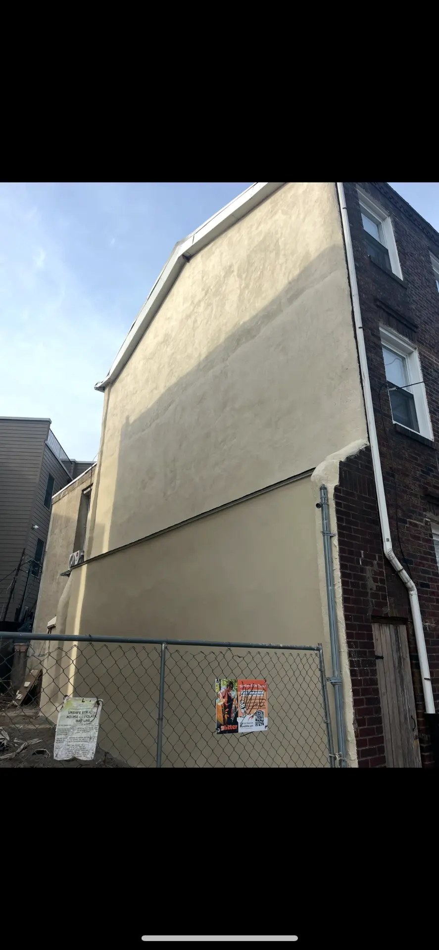 Craftsman troweling new stucco onto a home exterior in Media, PA